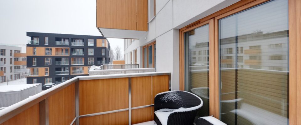 Nowoczesny balkon z widokiem na osiedle zimą