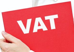Osoba trzymająca czerwony folder z napisem VAT