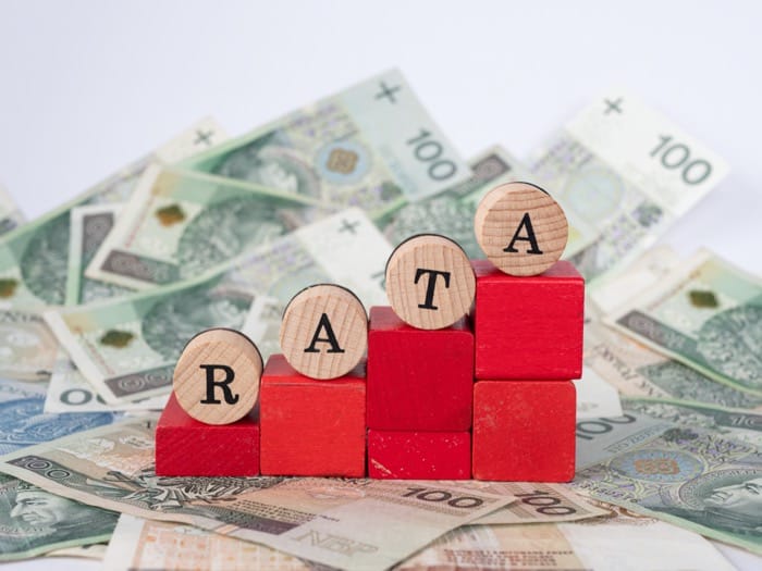 Klocki z napisem RATA na tle polskich banknotów — symbol systemu finansowego PRL