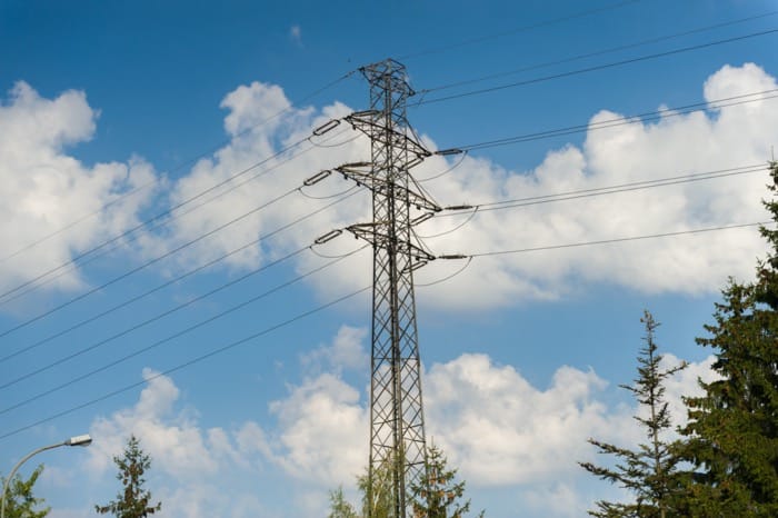 Linia energetyczna na tle błękitnego nieba z chmurami